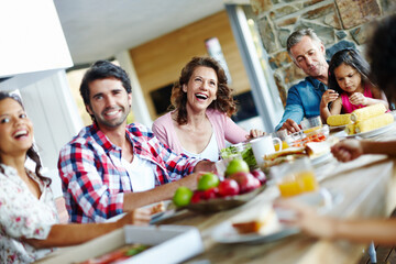 Poster - Enjoying mealtimes as a family. A happy family enjoying a meal time together.