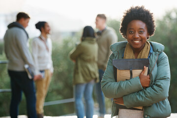 Canvas Print - Study break with friends. Portrait of a young student standing outside with friends in the background.