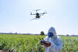© Tongpool - Farmer fly drone spray insecticide using high technology increasing productivity agriculture
