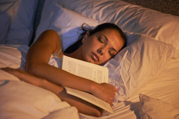 Wall Mural - She fell asleep reading again. Shot of an attractive young woman sleeping holding book.