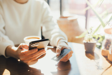 Woman holding smartphone and credit card in her hand.