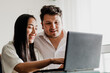 © artrolopzimages - Photo of young couple looking at a web page on a laptop, planning something, shopping, etc. Concept of lifestyle, human relations, internet.