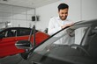 © Serhii - A young Indian man chooses a new car at a car dealership