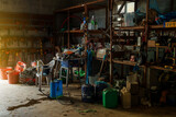 Fototapeta Sawanna - farm impliments cluttered inside a barn