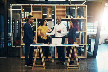 Wall Mural - Planning brings everyone together. Shot of a group of designers having a discussion in a modern office.