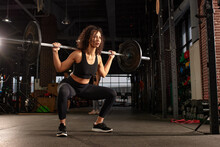 Young Pretty African American Sports Woman In Fitness Gym Lifting Up Empty Bar In Gym, Doing Warm Up, Barbell Squat, Butt Workout