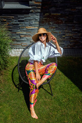 Wall Mural - Full length of an attractive woman wearing sunhat and sunglasses while relaxing outdoor