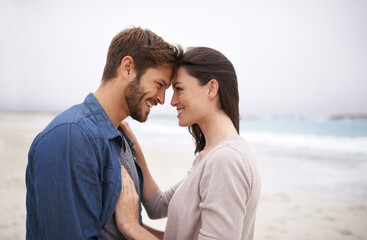 Wall Mural - Nature brings out that natural kind of love. Cropped shot of a romantic young couple at the beach.