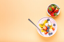 Healthy Breakfast Or Dessert Yogurt Bowl With Fresh Banana, Strawberry, Blueberry, Cocos, Kiwi Top View On Minimal Pastel Paper Background With Spoon. Copy Space