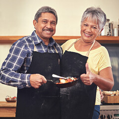 Canvas Print - Dinner is served. Shot of a mature couple cooking together at home.