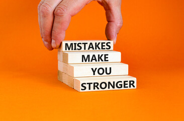 Wall Mural - Mistake make stronger symbol. Concept words Mistakes make you stronger on wooden blocks. Beautiful orange table orange background. Businessman hand. Business mistake make stronger concept. Copy space.