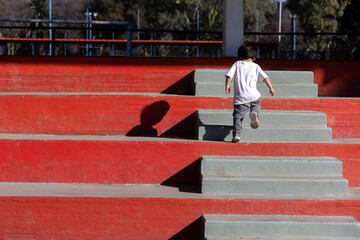 Boy going upstairs outdoors, growing up concept