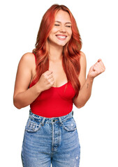 Wall Mural - Young redhead woman wearing casual clothes excited for success with arms raised and eyes closed celebrating victory smiling. winner concept.