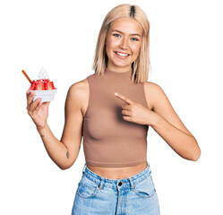 Poster - Beautiful young blonde woman eating strawberry ice cream smiling happy pointing with hand and finger