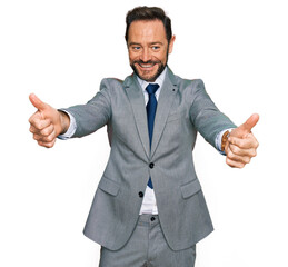 Poster - Middle age man wearing business clothes approving doing positive gesture with hand, thumbs up smiling and happy for success. winner gesture.