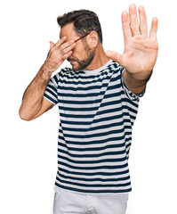 Sticker - Middle age man wearing casual clothes and glasses covering eyes with hands and doing stop gesture with sad and fear expression. embarrassed and negative concept.