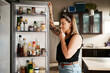 © Chanelle M/peopleimages.com - Hmm...what to make for dinner. Shot of a young woman searching inside a refrigerator at home.