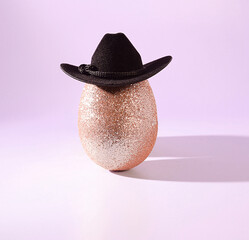 Easter Goes West: A Sparkling, Glittery Gold Easter Egg Wearing a Cowboy Hat on a Pastel Pink Background, Cowboy Easter