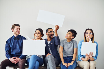 Poster - Lets put whats on our minds on a message. Shot of a diverse group of creative employees holding up speech bubbles inside.