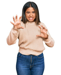 Sticker - Young latin girl wearing wool winter sweater smiling funny doing claw gesture as cat, aggressive and sexy expression