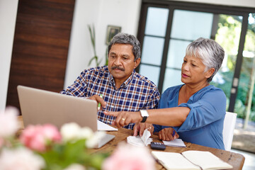 Wall Mural - Budgeting with the help from technology. Shot of a senior couple working on their budget together at home.