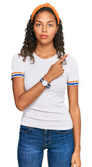 Wall Mural - Young african american girl wearing casual clothes pointing with hand finger to the side showing advertisement, serious and calm face