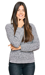 Canvas Print - Young brunette woman wearing casual winter sweater looking confident at the camera smiling with crossed arms and hand raised on chin. thinking positive.