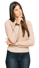 Sticker - Young brunette woman wearing casual winter sweater with hand on chin thinking about question, pensive expression. smiling with thoughtful face. doubt concept.