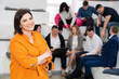 © andrey - a brunette woman in an orange blouse with men and women in the office.