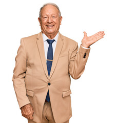 Wall Mural - Senior caucasian man wearing business suit and tie smiling cheerful presenting and pointing with palm of hand looking at the camera.