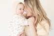 © kristineldridge - close up of mother and baby daughter with floral dress and bonnet