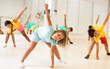 © JackF - Little girl warming up with group of children in dance class, doing stretching exercises before training.