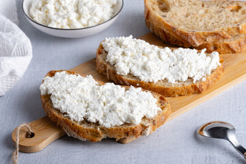 Bread with curd cheese on wooden board