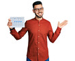 © Krakenimages.com - Young hispanic man with beard holding travel calendar celebrating achievement with happy smile and winner expression with raised hand