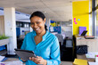 © Wavebreak Media - Portrait of african american businesswoman using tablet and smiling at office with copy space
