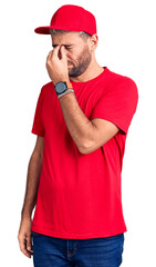 Poster - Young handsome blond man wearing t-shirt and cap tired rubbing nose and eyes feeling fatigue and headache. stress and frustration concept.