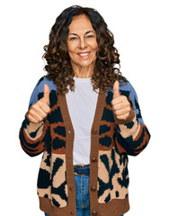 Sticker - Middle age hispanic woman wearing casual clothes success sign doing positive gesture with hand, thumbs up smiling and happy. cheerful expression and winner gesture.