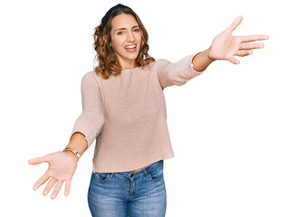 Beautiful young caucasian woman wearing casual sweater looking at the camera smiling with open arms for hug. cheerful expression embracing happiness.