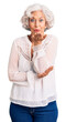 © Krakenimages.com - Senior grey-haired woman wearing casual clothes looking at the camera blowing a kiss with hand on air being lovely and sexy. love expression.