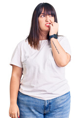 Sticker - Young plus size woman wearing casual clothes looking stressed and nervous with hands on mouth biting nails. anxiety problem.