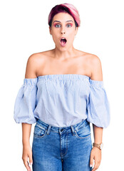 Sticker - Young beautiful woman with pink hair wearing casual clothes afraid and shocked with surprise and amazed expression, fear and excited face.