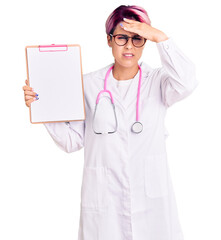 Canvas Print - Young beautiful woman with pink hair wearing doctor stethoscope holding clipboard with medical report stressed and frustrated with hand on head, surprised and angry face