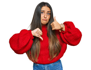 Sticker - Beautiful hispanic woman wearing casual clothes doing thumbs up and down, disagreement and agreement expression. crazy conflict