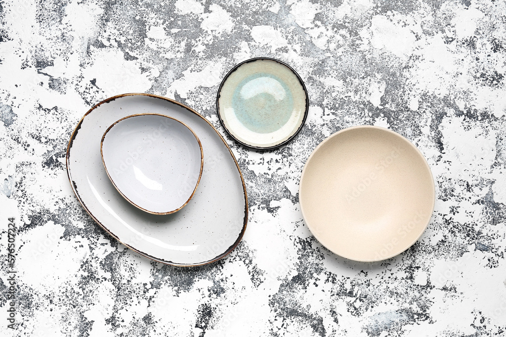 Composition with clean ceramic plates on grey grunge background