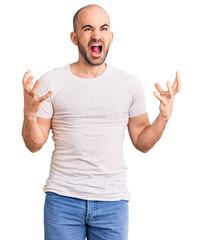 Sticker - Young handsome man wearing casual t shirt crazy and mad shouting and yelling with aggressive expression and arms raised. frustration concept.