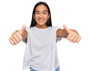 Wall Mural - Young asian woman wearing casual white t shirt approving doing positive gesture with hand, thumbs up smiling and happy for success. winner gesture.