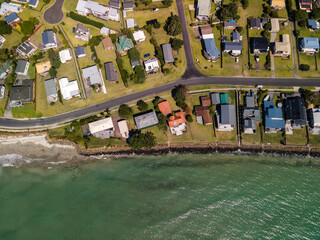 Poster - Luxury beach front properties in coastal town with swirling low tide patterns in the sand seen from above.