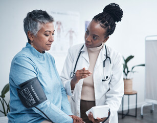 Wall Mural - Black woman, doctor and senior patient with blood pressure reading for wellness, advice and conversation. Medic, elderly client and medical tools for health, cardiology and results in hospital office