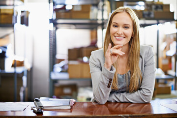 Wall Mural - Weve got your delivery. Portrait of a young woman standing at a counter in a warehouse.