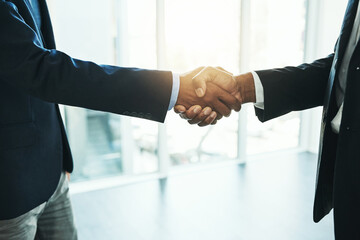 Poster - Reaching their business goals together. Shot of two unrecognisable businessmen shaking hands in an office.